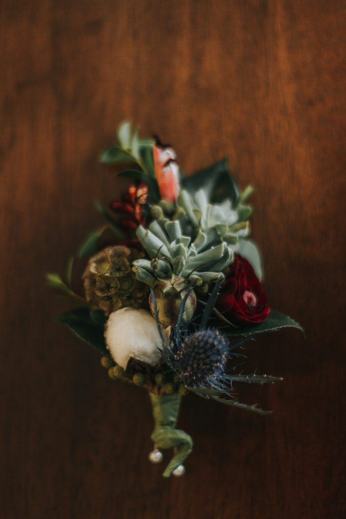 Bohemian corsage featuring succulents, cotton, thistle and pods.