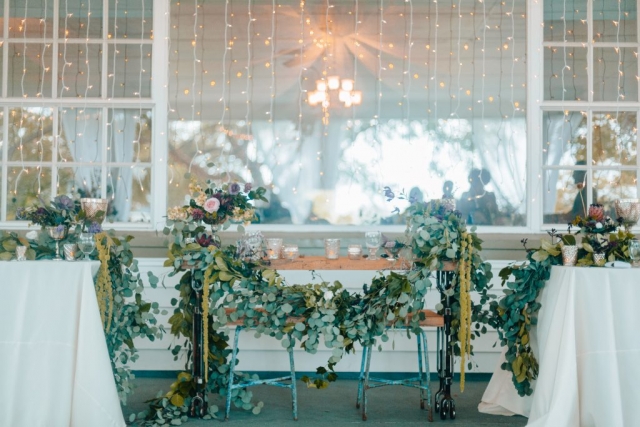 Bohemian sweetheart table with lush garlands.