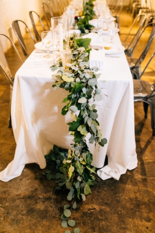 Elegant feast table with fresh garland and candles.