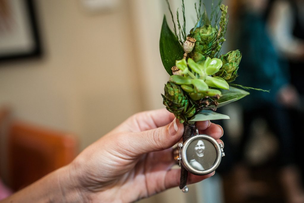 All green boutonniere with succulents, hops and poppy pods.