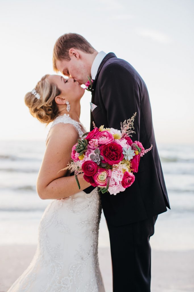 Hot pink bridal bouquet featuring garden roses, ranunculus and succulents.