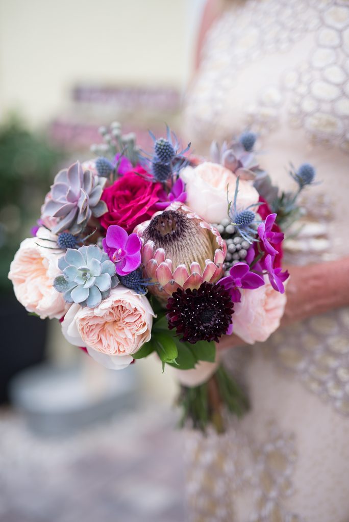Textured bridal bouquet in pink, purple and blush featuring king protea, succulents, garden roses and thistle.
