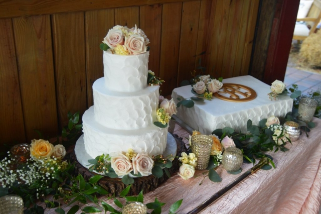Rustic fresh cake flowers with roses and greenery.