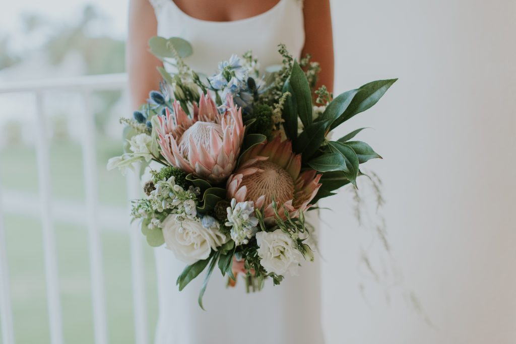 Textured bridal bouquet featuring king proteas, garden roses and greenery.