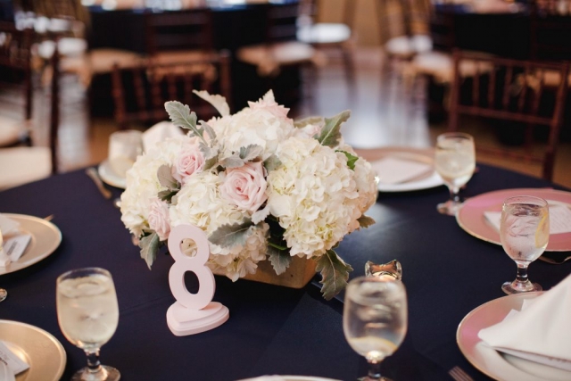 Simple and romantic white and blush centerpiece of hydrangeas, roses and dusty miller.