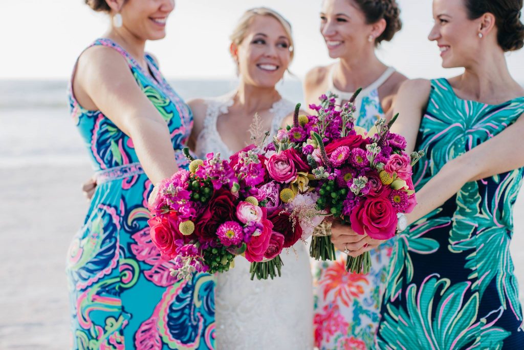 Hot pink bridal and bridesmaid bouquets with roses, ranunculus, asters, bille balls, hypericum and stock.