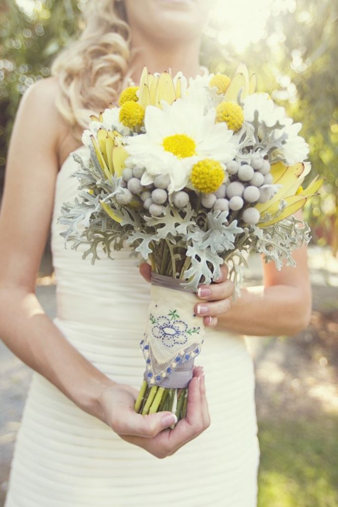 Wild country bridal bouquet of white, grey and yellow with berzilia, dusty miller, leucadendron and bille balls.