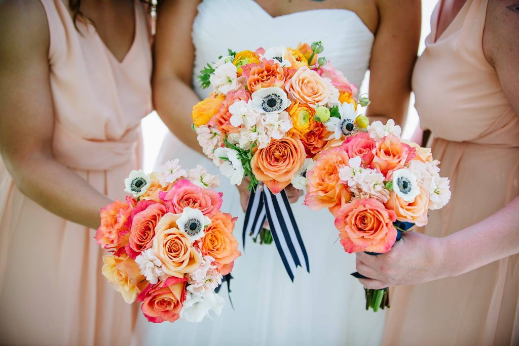 Nautical bridal and bridesmaid bouquets in peach, white and coral with anenomes, ranunculus, roses and stock.
