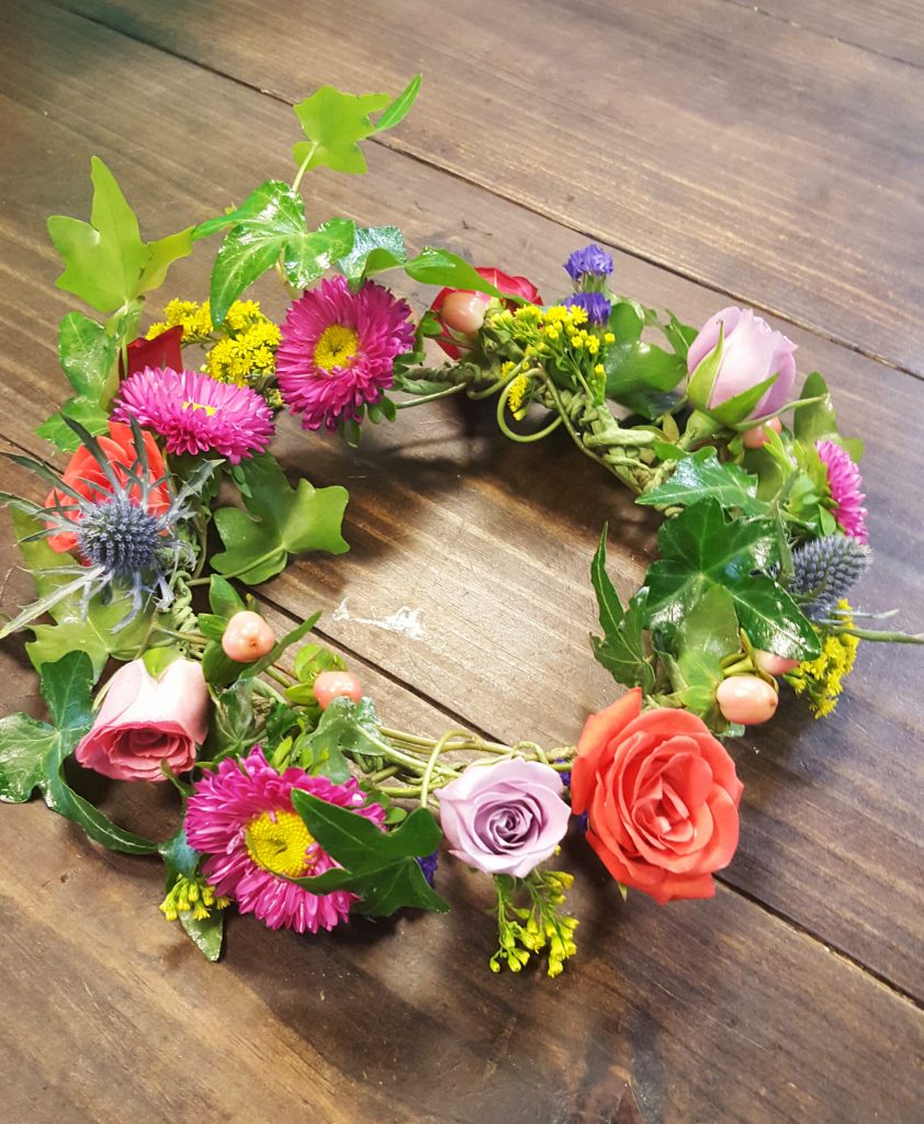 Mixed spring flower crown with roses, asters, thistle and ivy.