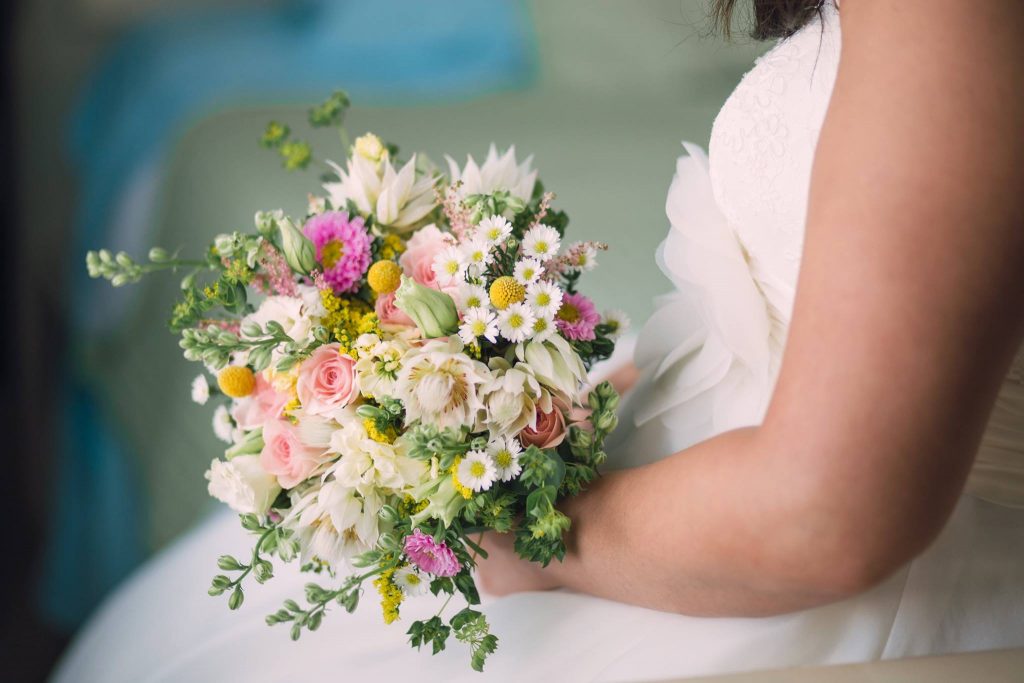 Wild flower bridal bouquet with blushing bride, monte casino, bille balls, lisianthus, larkspar and asters.