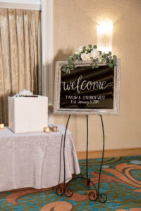 Simple white flower and eucalyptus on welcome sign at wedding reception in Vinoy Grand Ballroom in St. Petersburg, Florida.