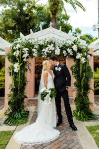 Ceremony arch of tropical greenery and white orchids in the Vinoy's Tea Garden in St. Petersburg, Florida.