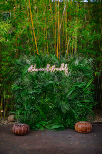 Tropical greenery photo backdrop at wedding reception at Nova 535 in St. Petersburg, Florida.