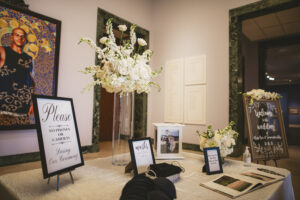 Entrance sign in table with white flower arrangements and welcome sign for wedding ceremony at Museum of Fine Arts in St. Petersburg, Florida.