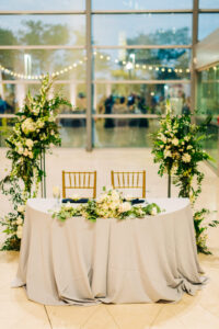 Asymmetrical floral sweetheart table backdrop at wedding reception at Museum of Fine Arts in St. Petersburg, Florida.