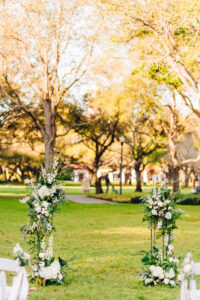 Asymmetrical open arch for white flowers and greenery for outdoor wedding ceremony in St. Petersburg, Florida.