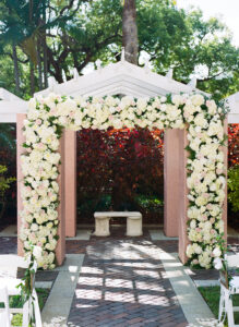 Classic white arbor flowers for outdoor wedding ceremony in the Vinoy Tea Garden in St. Petersburg, Florida.