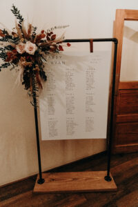 Boho Fall inspired corner floral piece on seating chart for wedding reception at Armature Works in Tampa, Florida.
