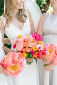 Colorful pink peony and ranunculus bride and bridesmaid bouquets.