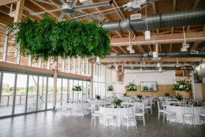 Lush greenery chandelier over dance floor at wedding reception at Tampa River Center in Tampa, Florida.