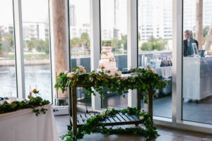 Organic greenery garland on cake table at wedding reception at Tampa River Center in Tampa, Florida.