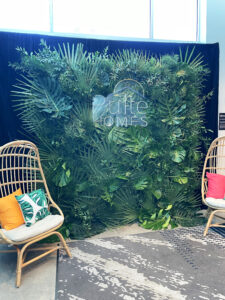 Tropical greenery photo backdrop for corporate event.