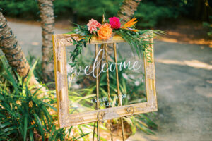 Bright tropical flower piece on welcome sign for wedding reception at Sunken Gardens in St. Petersburg, Florida.