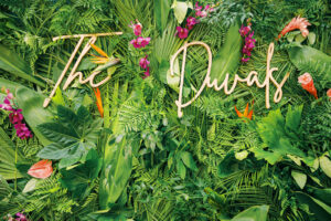 Tropical greenery and flower photo backdrop at wedding reception at Sunken Gardens in St. Petersburg, Florida.