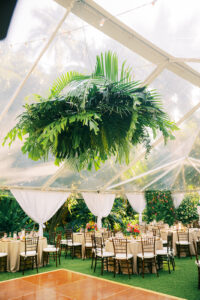 Tropical greenery chandelier over dance floor at wedding reception at Sunken Gardens in St. Petersburg, Florida.