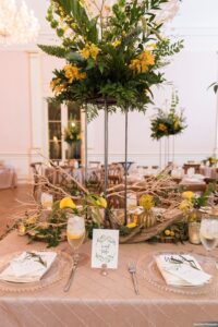 Eclectic, masculine woodland feasting table scape with yellow flowers, driftwood and manzanita branches at wedding reception at Museum of Fine Arts in St. Petersburg, Florida.