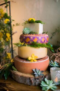 Succulent, greenery and yellow cake flowers of cheese wheel cake at wedding reception at Museum of Fine Arts in St. Petersburg, Florida.
