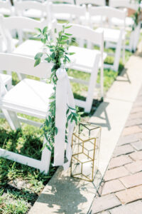 Simple aisle greenery and lanterns for outdoor wedding ceremony at the Vinoy Tea Garden in St. Petersburg, Florida.
