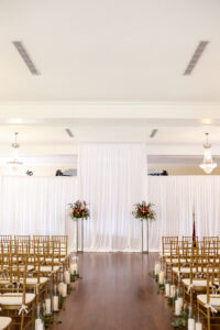 Classic and romantic wedding ceremony of aisle greenery, candles and altar arrangements at the Orlo House in Tampa, Florida.