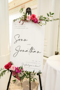 Hot pink flower pieces on welcome sign for wedding ceremony at Vinoy in St. Petersburg, Florida.