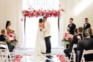 Hot pink flower header on arch and aisle arrangements for ceremony at the Vinoy in St. Petersburg, Florida.