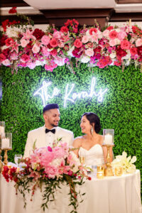 Bright hot pink flower and greenery backdrop for sweetheart table at wedding reception at the Vinoy in St. Petersburg, Florida.