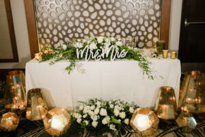 Romantic sweetheart table with white floral centerpieces and gold lanterns at wedding reception at the Current Hotel in Tampa, Florida.