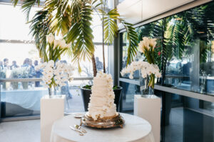 Modern cascading orchid cake flowers with orchid and calla lily arrangements backdrop at wedding reception at Museum of Fine Arts in St. Petersburg, Florida.