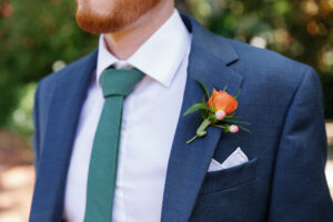 Orange spray rose and pink hypericum groom's boutonniere in St. Petersburg, Florida.