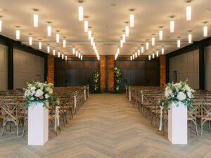 Romantic wedding ceremony with aisle entrance arrangements, aisle flowers and arch at Armature Works in Tampa, Florida.