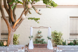 Romantic and classic outdoor garden wedding ceremony with hanging lanterns and white arbor at Museum of Fine Arts in St. Petersburg, Florida.