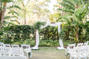 Organic arch of greenery and fabric for outdoor wedding ceremony in Tampa, Florida.