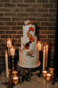 Rustic orange cascading cake flowers and candlelight at wedding reception at Urban Stillhouse in St. Petersburg, Florida.