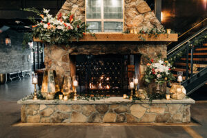 Organic rustic fireplace altar with flowers and candlelight for a ceremony at Urban Stillhouse in St. Petersburg, Florida.