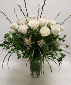 Lush arrangement of a dozen white roses, astillbe, and mixed greenery