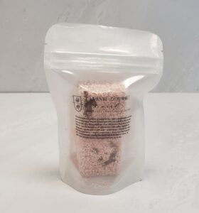 Pink shower steamer block scented with pepperberry, rose, and pepperment from Cleanse Gourmet
